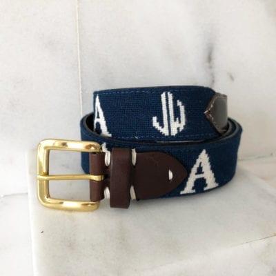 A blue belt with white letters and a brown leather buckle.