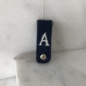A black key chain with the letter a on it.