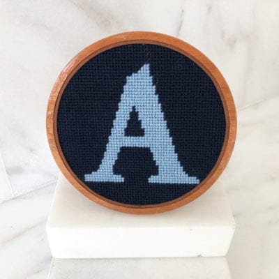 A wooden frame with a blue letter on it.
