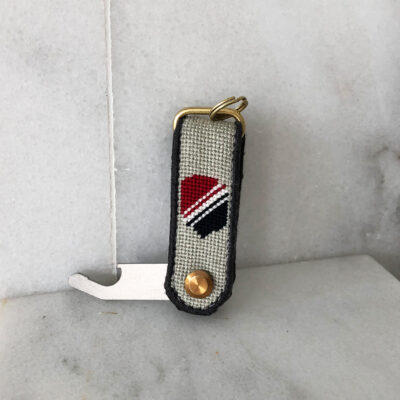 A key chain with a red, black and white design.
