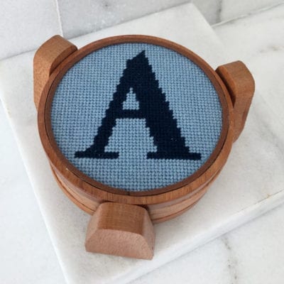 A wooden coaster with the letter a on it.