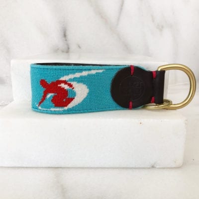 A blue key chain with a red and white fish on it.