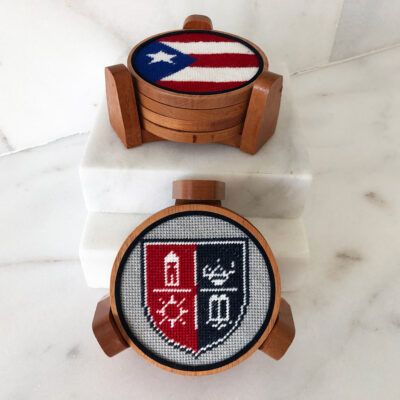 A wooden coaster with a picture of the flag and crest.