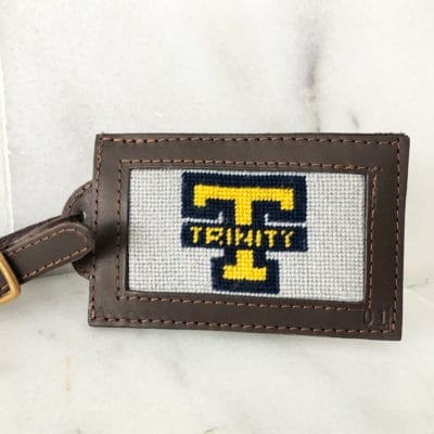 A brown leather luggage tag with the name " trinity ".