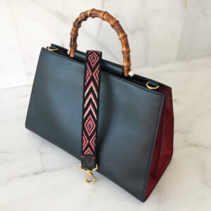 A black and red bag with bamboo handles