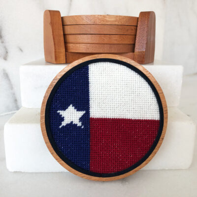 A wooden chair with a cross stitch picture of the texas flag.