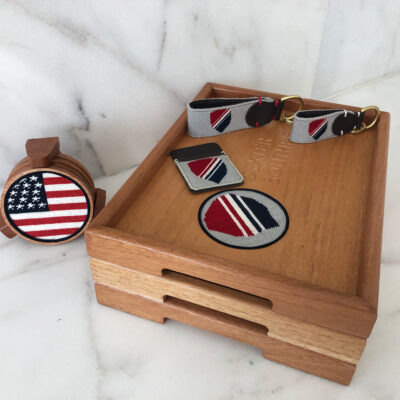 A wooden box with two matching cufflinks and one tie tack.