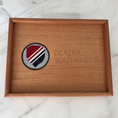 A wooden tray with a red, white and blue emblem on it.