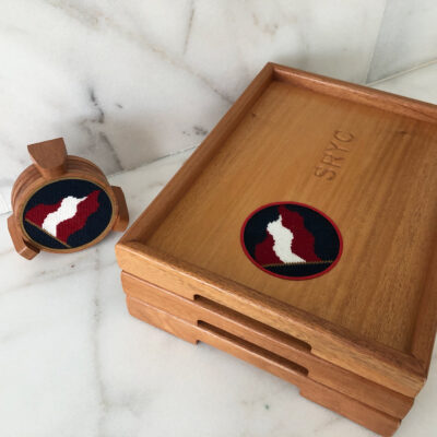 A wooden box and coaster set with a red, white and black design.