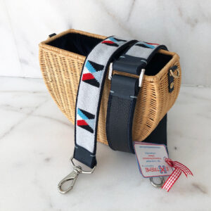 A straw purse with a strap and a card holder.