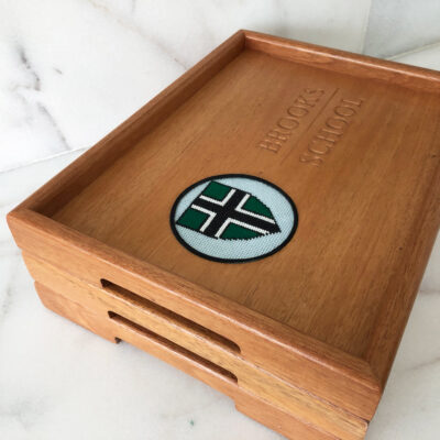 A wooden tray with a green and white cross on it.