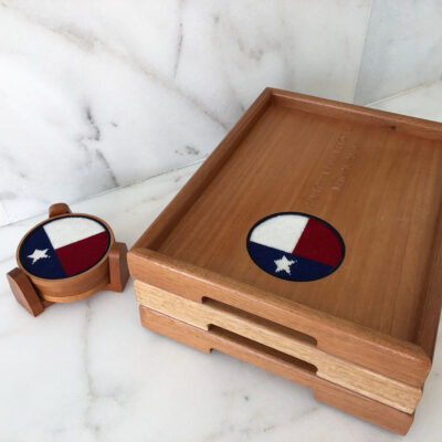 A wooden tray and coaster set with the texas state flag on it.