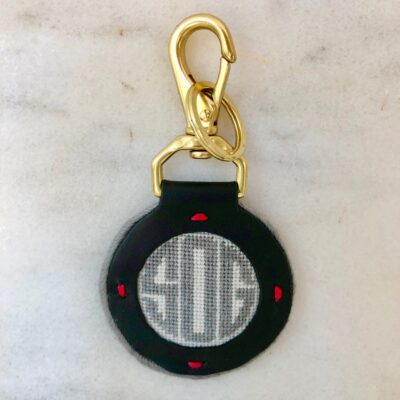 A black key chain with red dots and a circle.