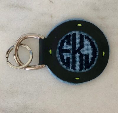 A key chain with the letters ekk on it.