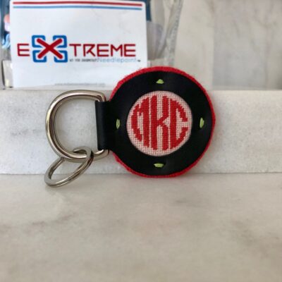 A key chain with the letters dxk on it.