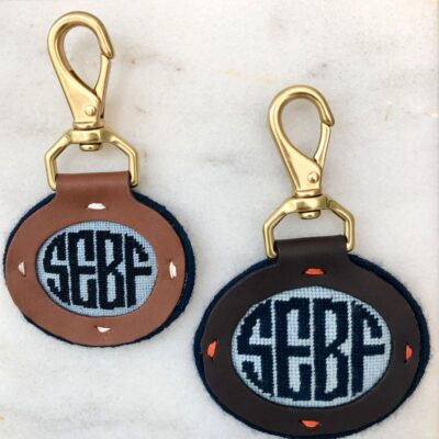 A pair of leather key chains with the letters sebf.