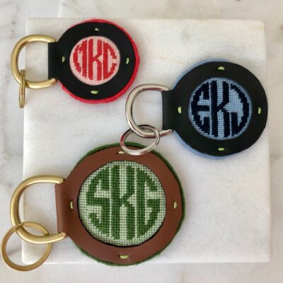 A set of three key chains with the letters skg on them.