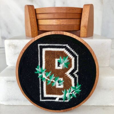 A wooden round with a cross stitch letter b on it.