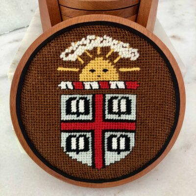 A cross stitch of the sun and the coat of arms.