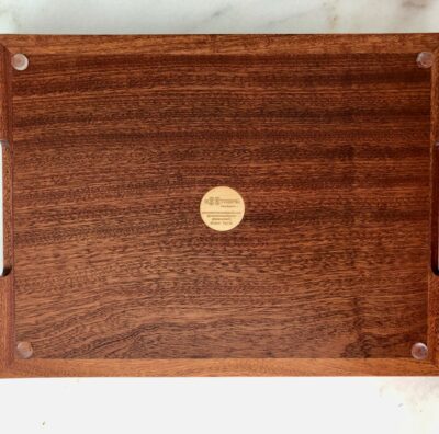 A wooden tray with a gold plaque on top of it.