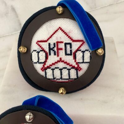 A close up of a cross stitch on the back of a medal